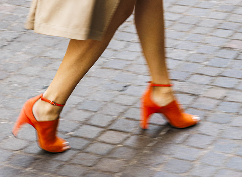 close up of a woman's legs wearing orange heels